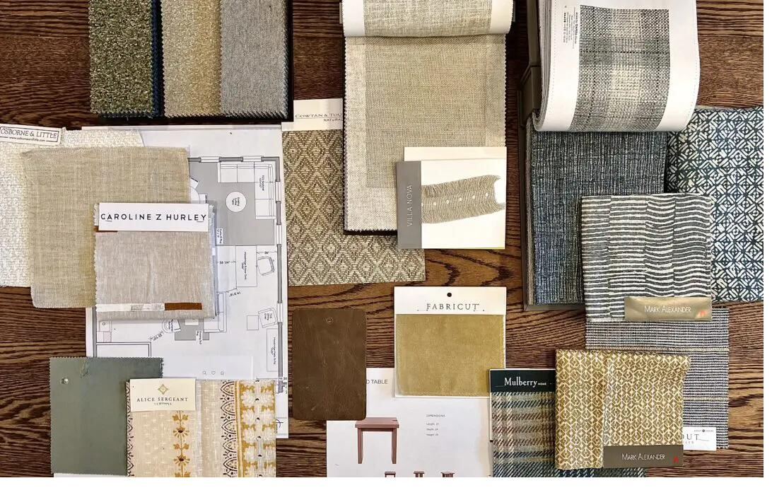 Fabric swatches and material samples laid out on wooden surface for client consultation — interior selection process at Siddhi Decorators